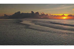Sunset illuminating calm ocean waves, a Nature Photo by Goinyk