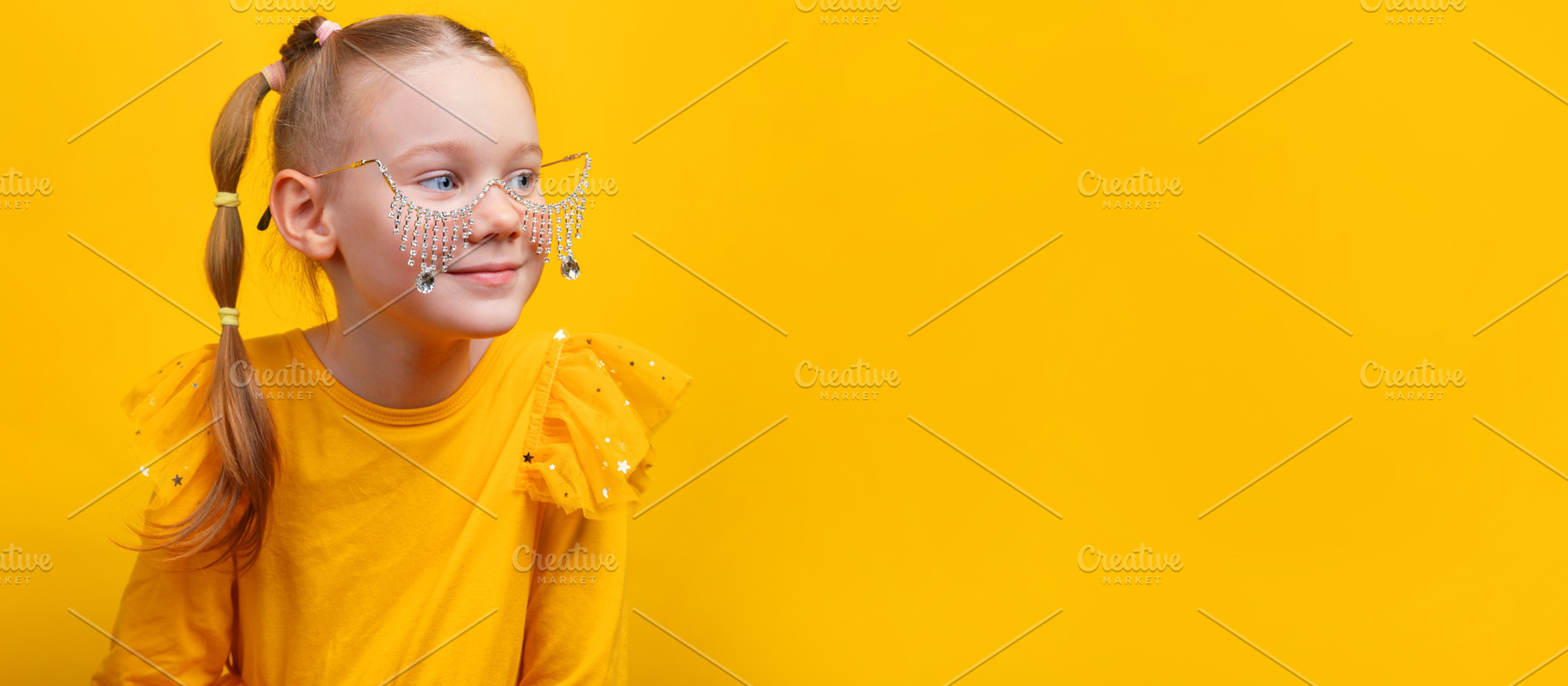 Cheerful girl in yellow dress with jeweled glasses looking sidew, a Person Photo by Ales Munt