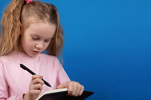 Child Writing in Notebook, a Person Photo by Ales Munt