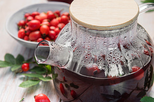 Steaming rosehip tea brewing in glass teapot with fresh rose hip, a Food & Drink Photo by Olena Rudo