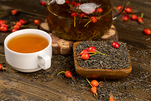 a cup of tea with rose fruits closeup, red rosehip fruits and hot green tea in, a Photo by rsoollAI