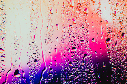 Raindrops on a blurred multicolored background containing abstract, drop, and