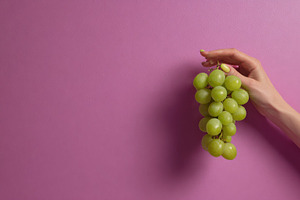 Hand holds bunch of green grapes, a Photo by Beautiful things