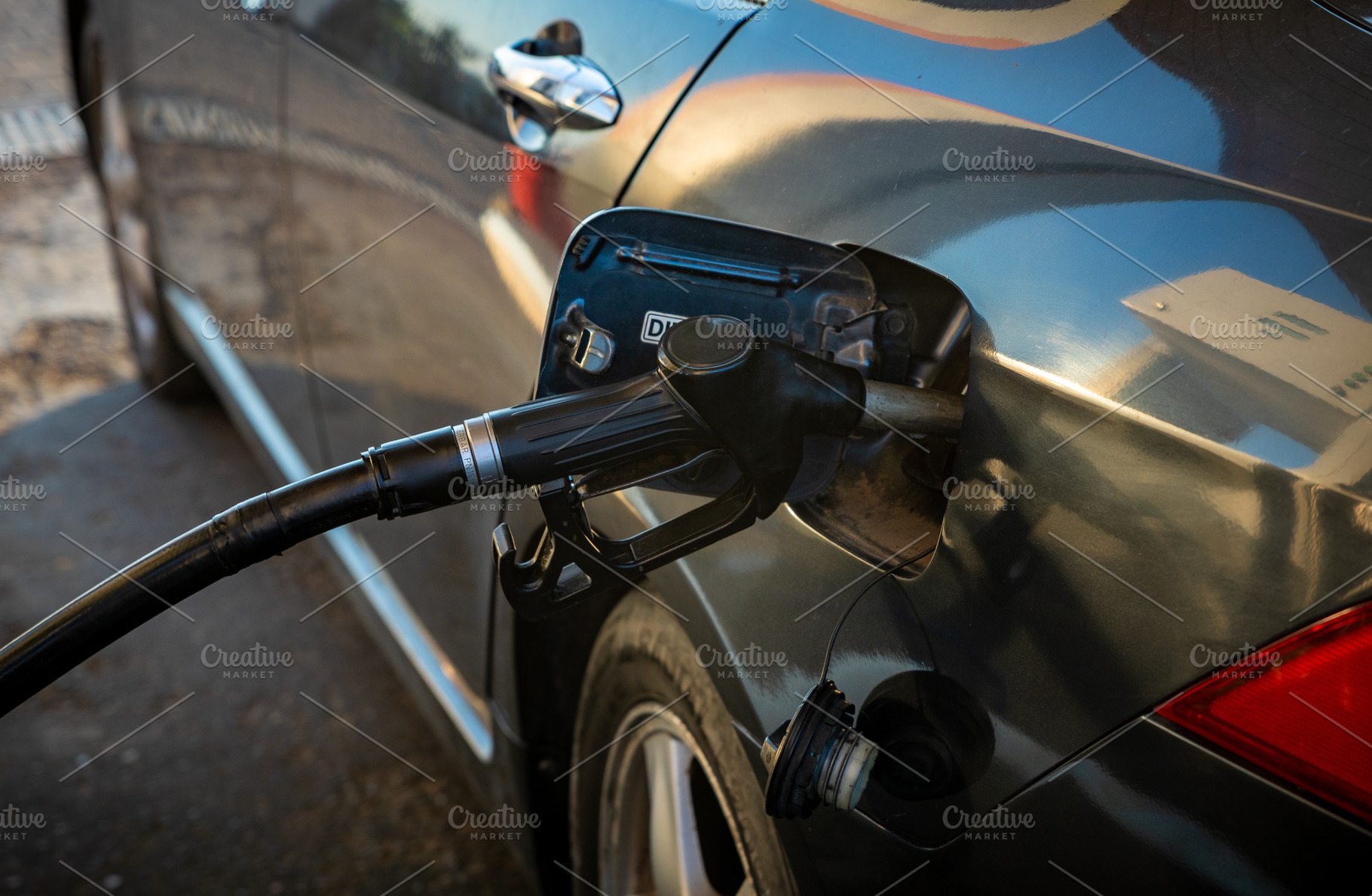Close-up view of a black car being refueled with gasoline at a modern gas stati, a Transportation Photo by Ales Munt