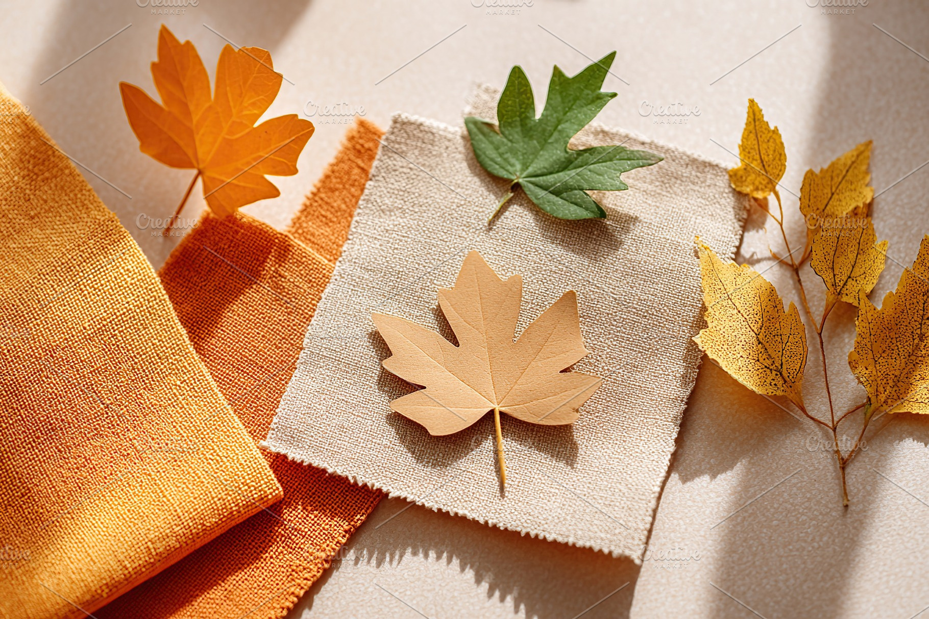 Autumn leaf cutouts arranged on fabric mockup showcasing seasonal design elemen, a Beauty & Fashion Photo by AlyaAnd