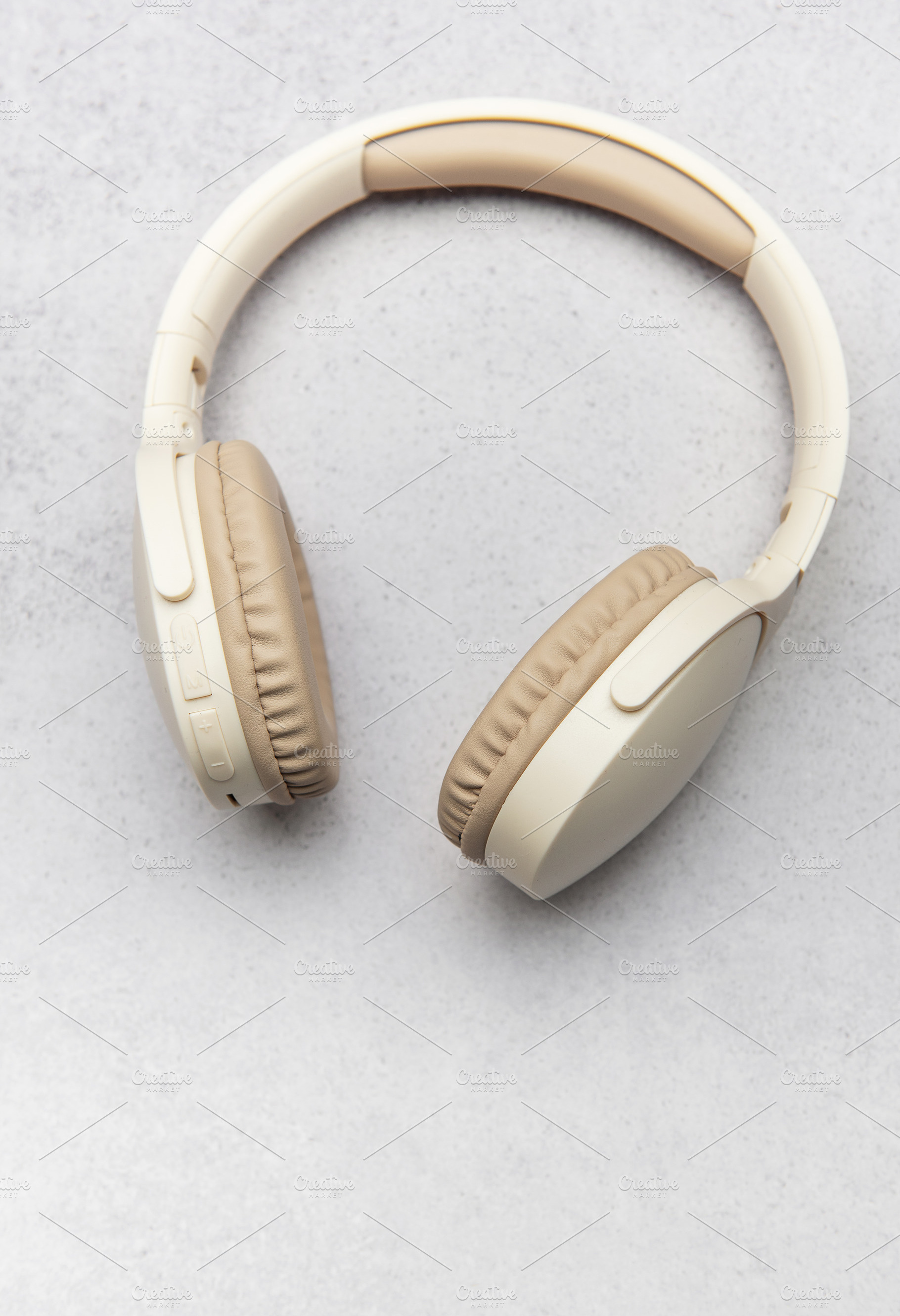 Modern wireless headphones lying on gray stone background, a Business Photo by Olena Rudo