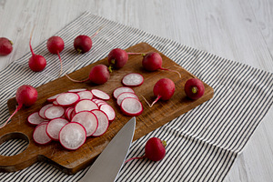 Raw Red Radish Slices on a Cutting Board, side view. Copy space., a Food & Drink Photo by LiudmylaChuhunova