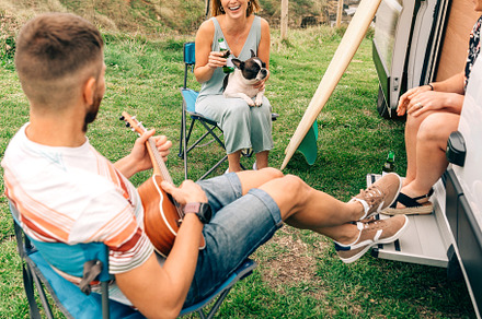 Friends with their dog drinking beer in front of their camper van, a Holiday Photo by davidpereiras