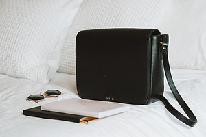 Bag and Sunglasses on Bed