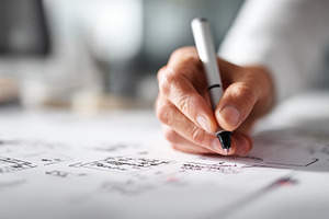 Hands drawing plans at a desk, a Photo by Beautiful things