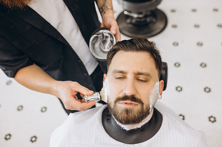Close-up male hands with shaving brush prepare beard of customer for cutting at, a Person Photo by Volodymyr Melnyk