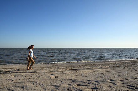 Woman walking along deserted beach