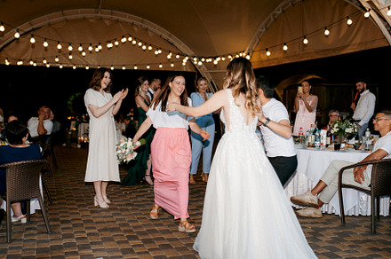 bride in a white dress throws a wedding bouquet
