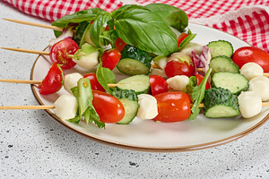Appetizer of fresh vegetables and cheese on wooden skewers, a Food & Drink Photo by ndanko