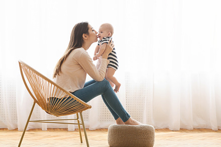 Mom holding newborn baby in hands an, a Background Photo by Prostock-Studio