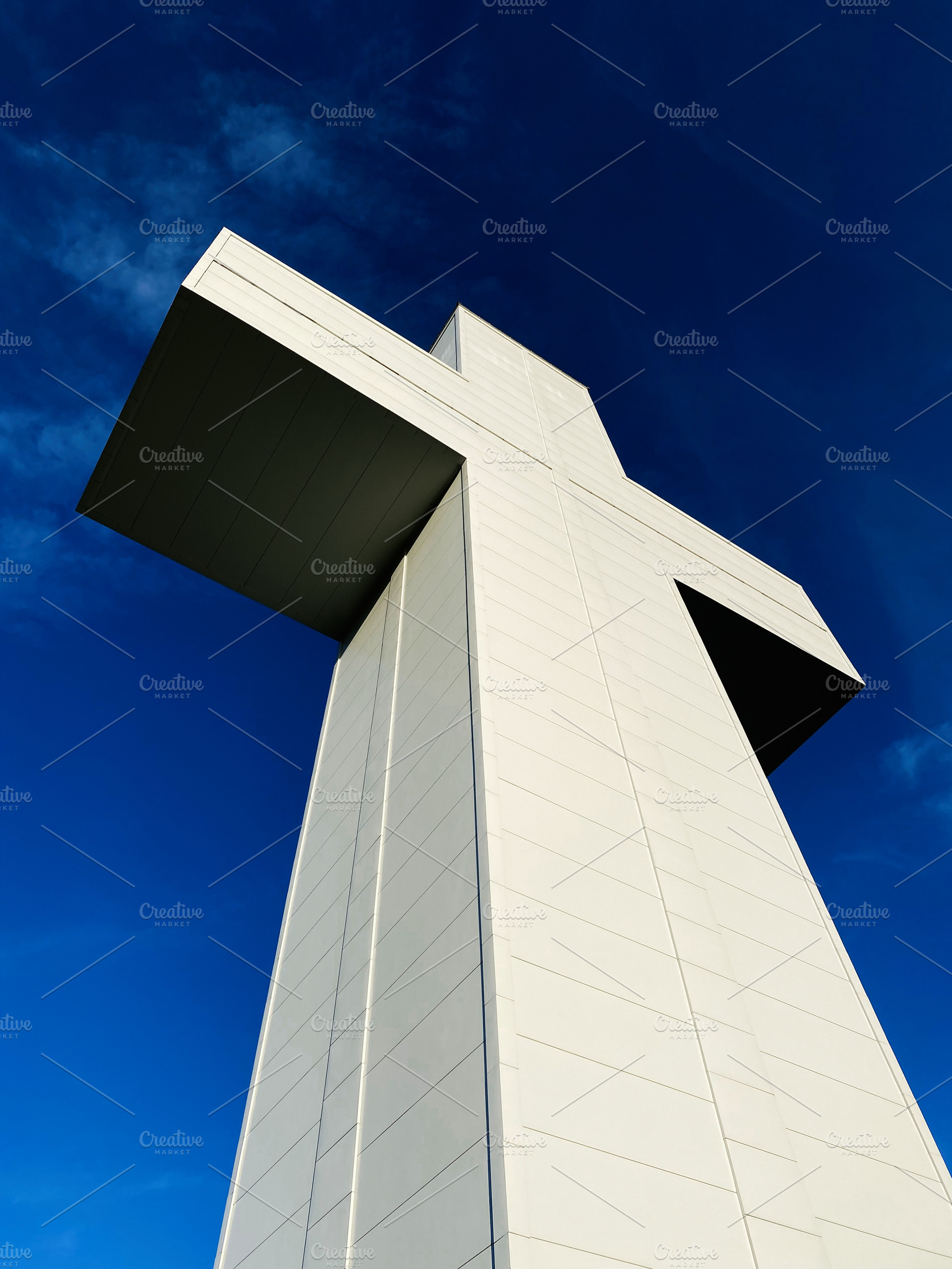 Modern white Bald Knob Cross of Peace shaped monument towering against a blue s, a Photo by AS photostudio