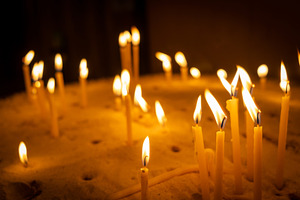 Burning candles with warm flames placed in a bed of sand, a Nature Photo by GoodGoods
