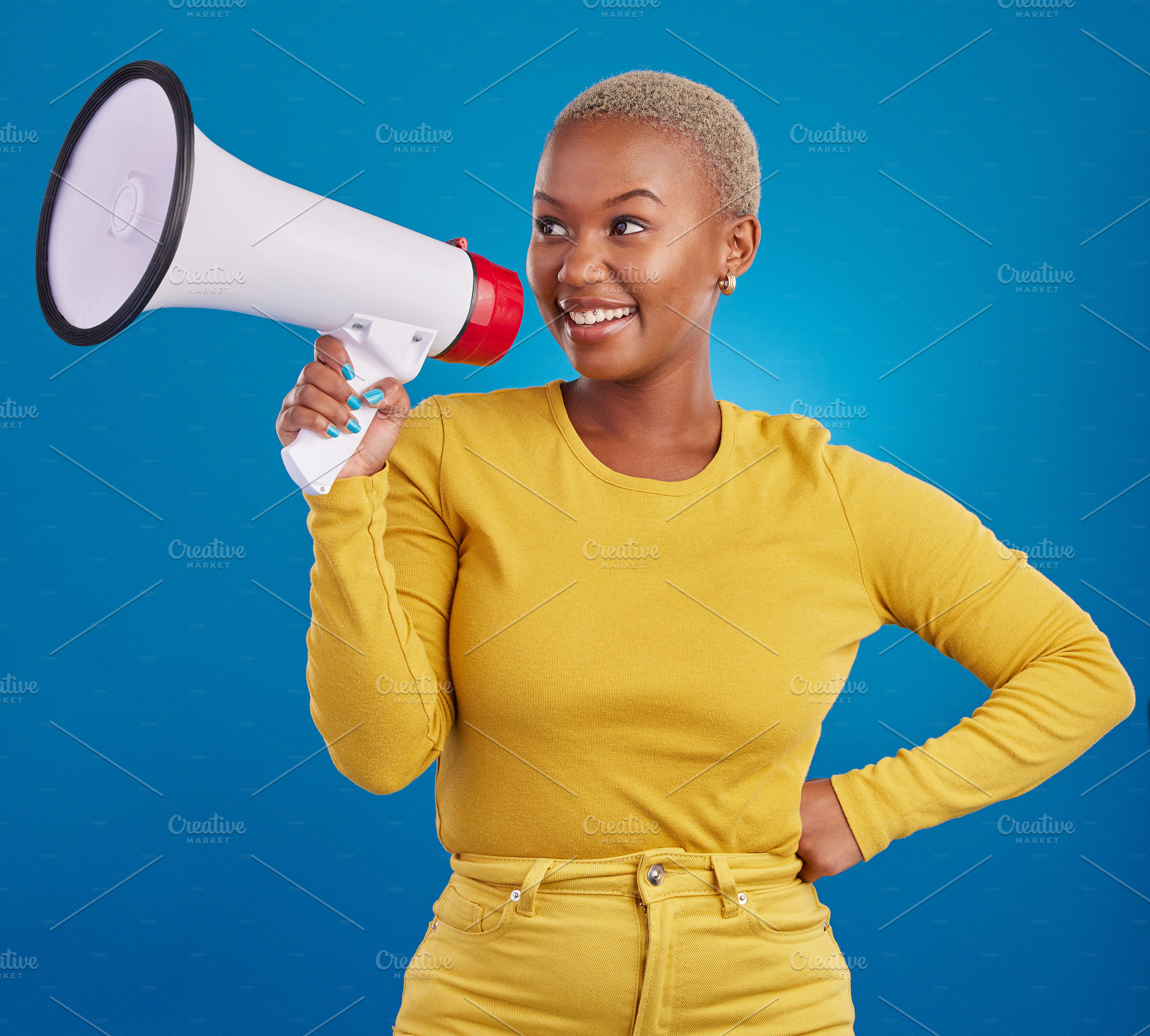 Black woman, megaphone and smile, protest and voice, freedom of speech and activism on blue background. Happy female, broadcast and speak out, rally and activist, loudspeaker with opinion in studio, a Photo by Peopleimages.com