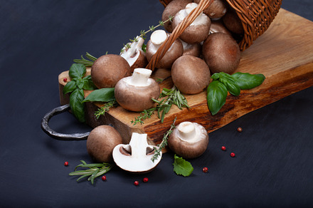 Fresh champignon mushrooms on dark wooden table