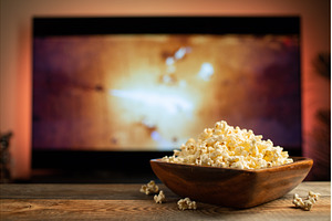 A wooden bowl of popcorn and remote, a Technology Photo by Budarinphoto