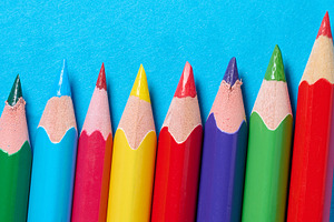 A row of sharpened colored pencils arranged diagonally on a blue, a School & Education Photo by ndanko