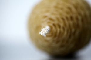 Close-up shot of a white cotton wick on a handmade beeswax egg candle with a ve, a Holiday Photo by Rohan Photography