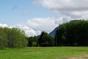 Tranquil park setting in Akranes, Iceland with trees and scenic mountain views, a Photo by AS photostudio