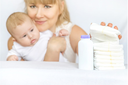 mother changes baby's diaper on a, a Person Photo by yanadjana