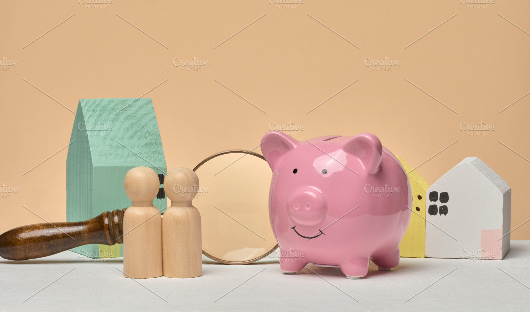 Pink piggy bank, wooden houses, wooden human figures and magnify, a Business Photo by ndanko