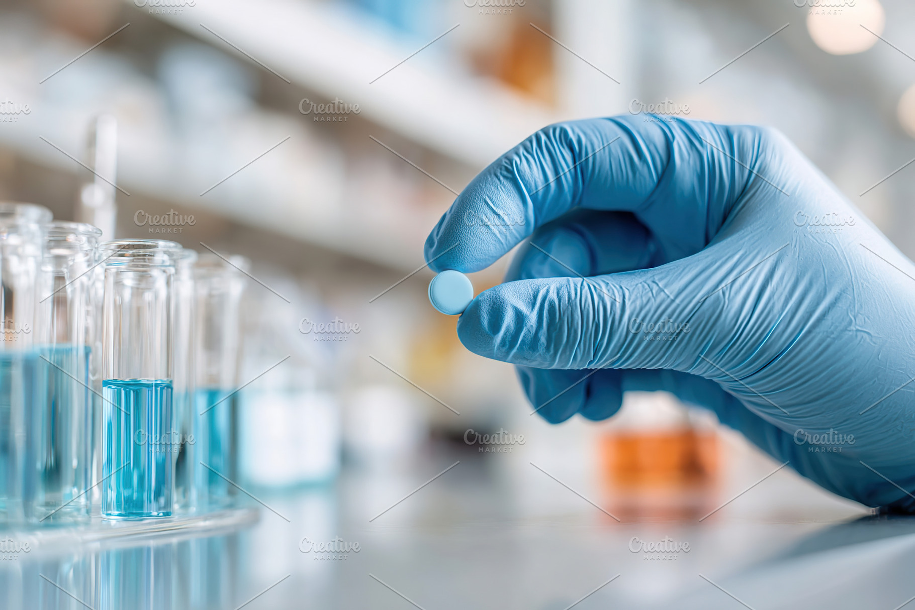 Gloved hand holding a blue tablet among laboratory glassware filled with liquid, a Photo by AlyaAnd