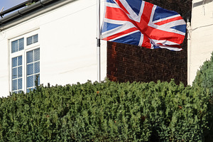 Union Jack flag flying high on a house, representing patriotism,, a Photo by Studio ANNA
