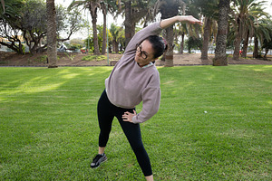 Woman doing side stretch exercise outdoors in a park, a Person Photo by etorres69