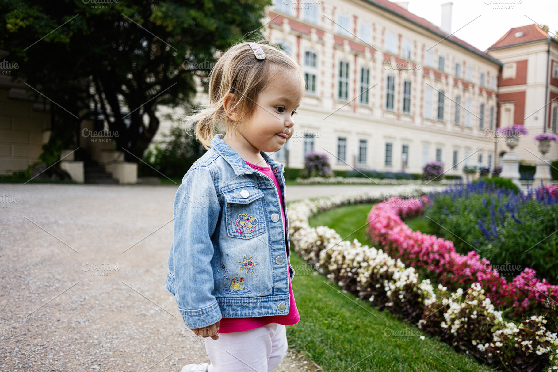 Young child exploring garden at historic architecture in Lancut, Poland, a Photo by AS photostudio