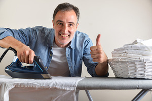 Man ironing shirt on an ironing board with ok gesture, a Sports & Recreation Photo by Davizro's Market