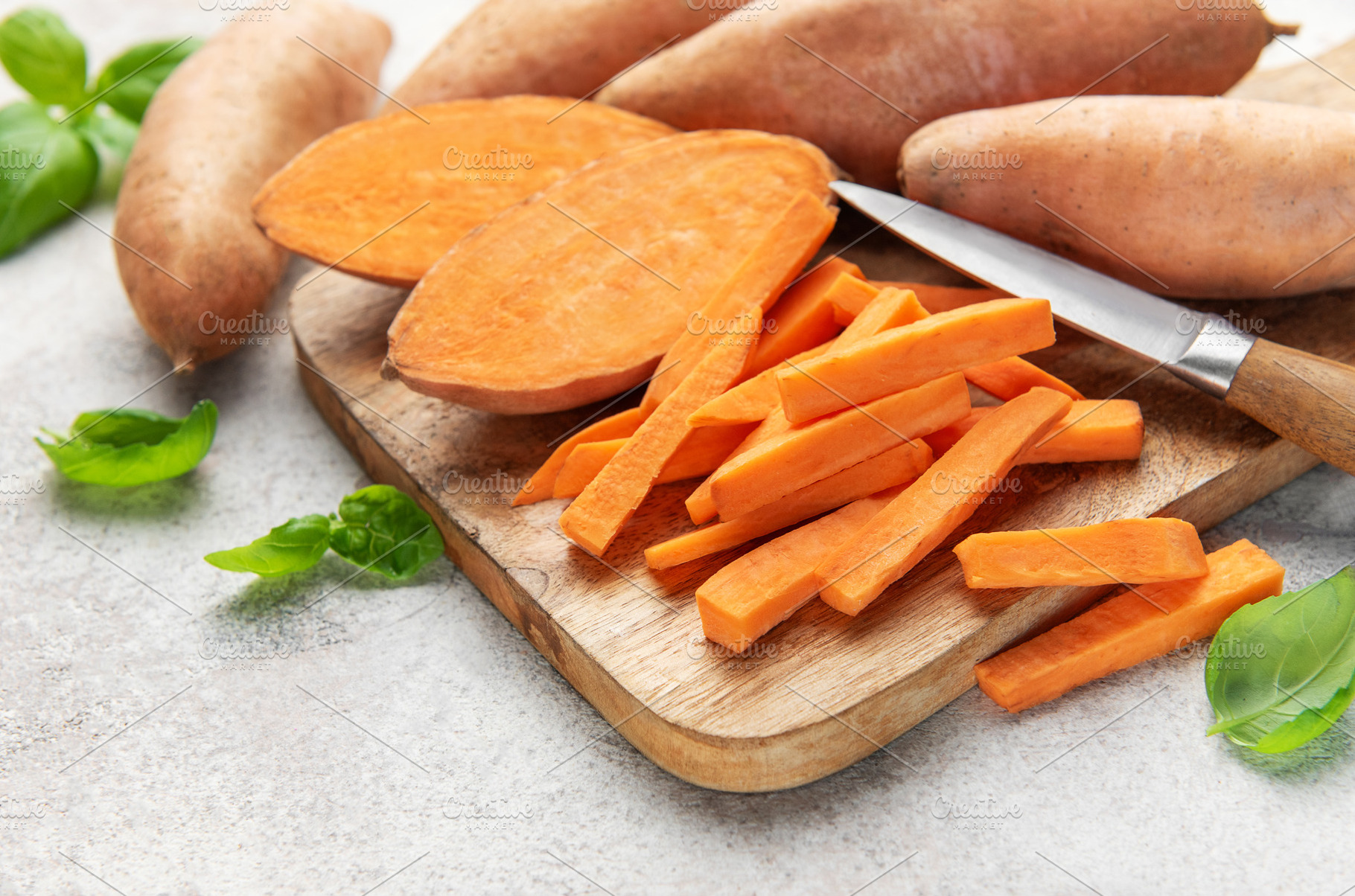 Sweet potato sticks with knife on wooden board, a Food & Drink Photo by Olena Rudo