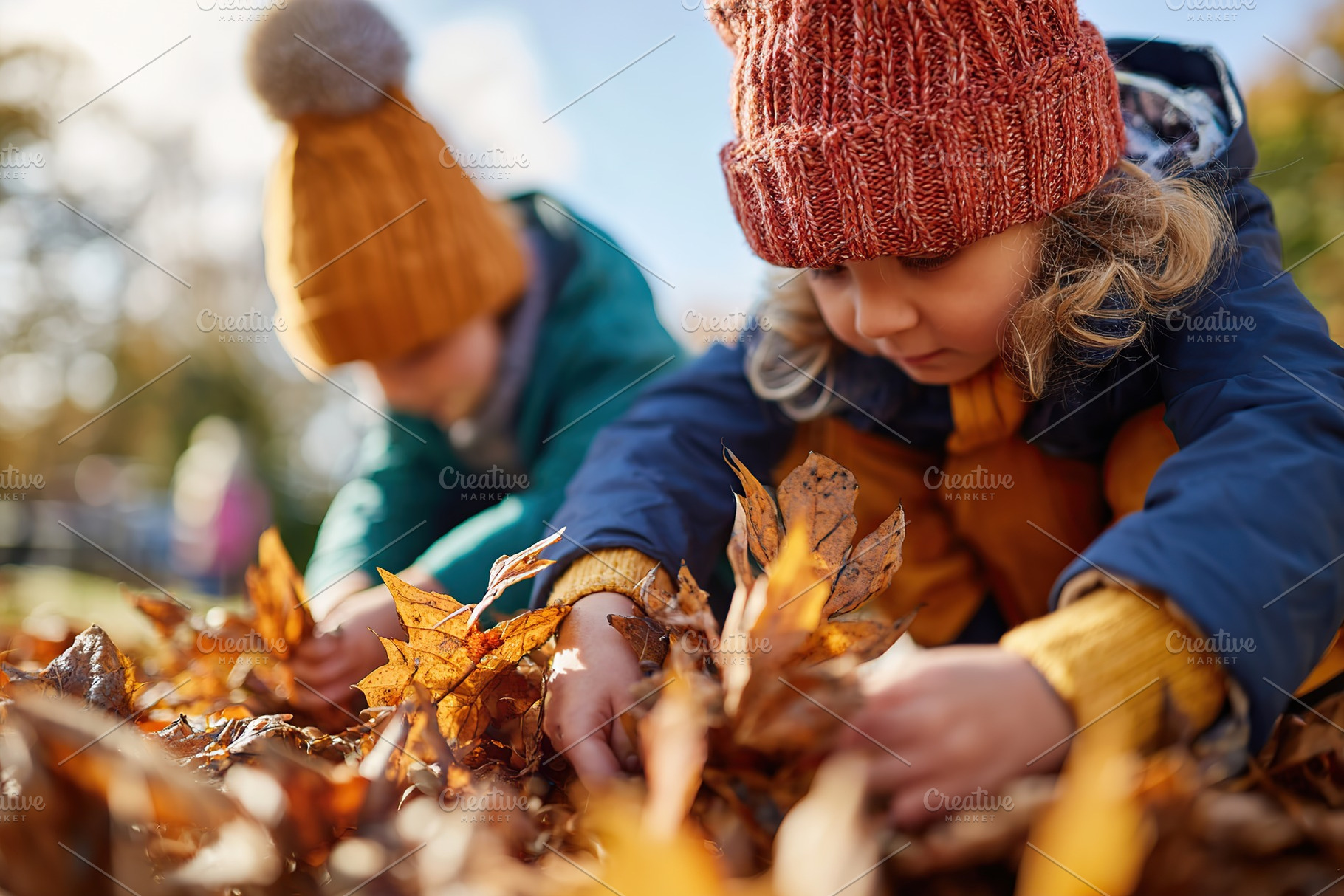 Children joyfully collecting colorful autumn leaves in a park during a bright f, a Person Photo by AlyaAnd