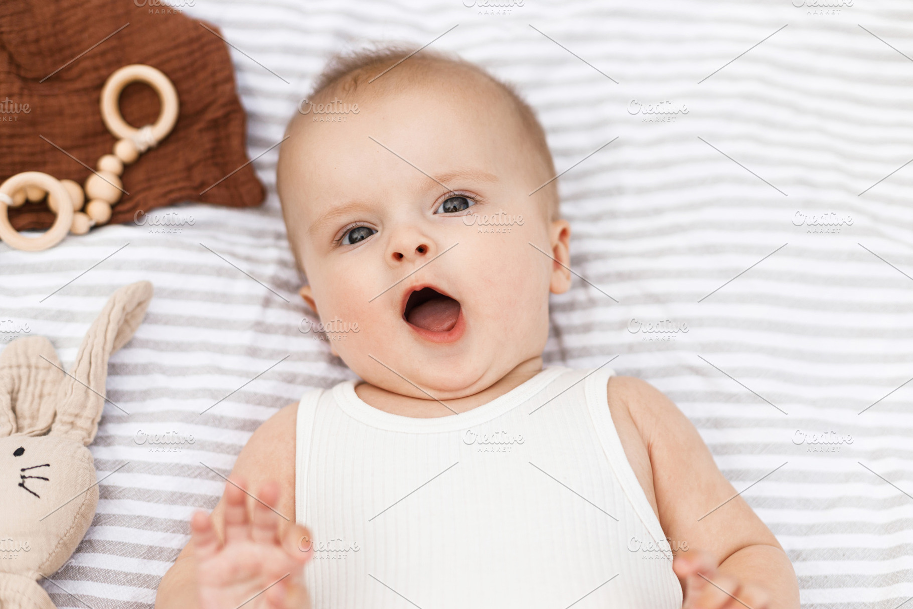 Beautiful happy baby lying on blanket with toys and teether in s, a Person Photo by Sonjachni