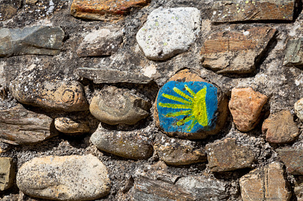 Hand painted sign of the Camino de Santiago on a stone wall