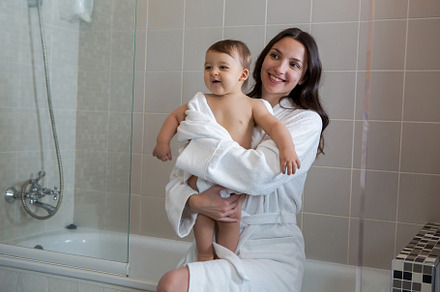 Mother in a bathrobe and with a child stock photo containing bathroom and, a Person Photo by SaulichPhoto