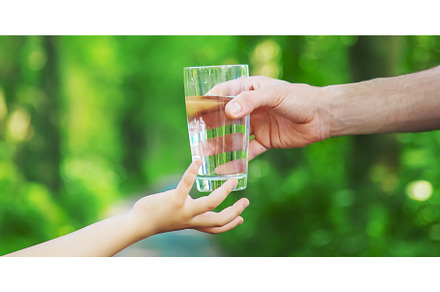 The father gives the child a glass, a Food & Drink Photo by yanadjana