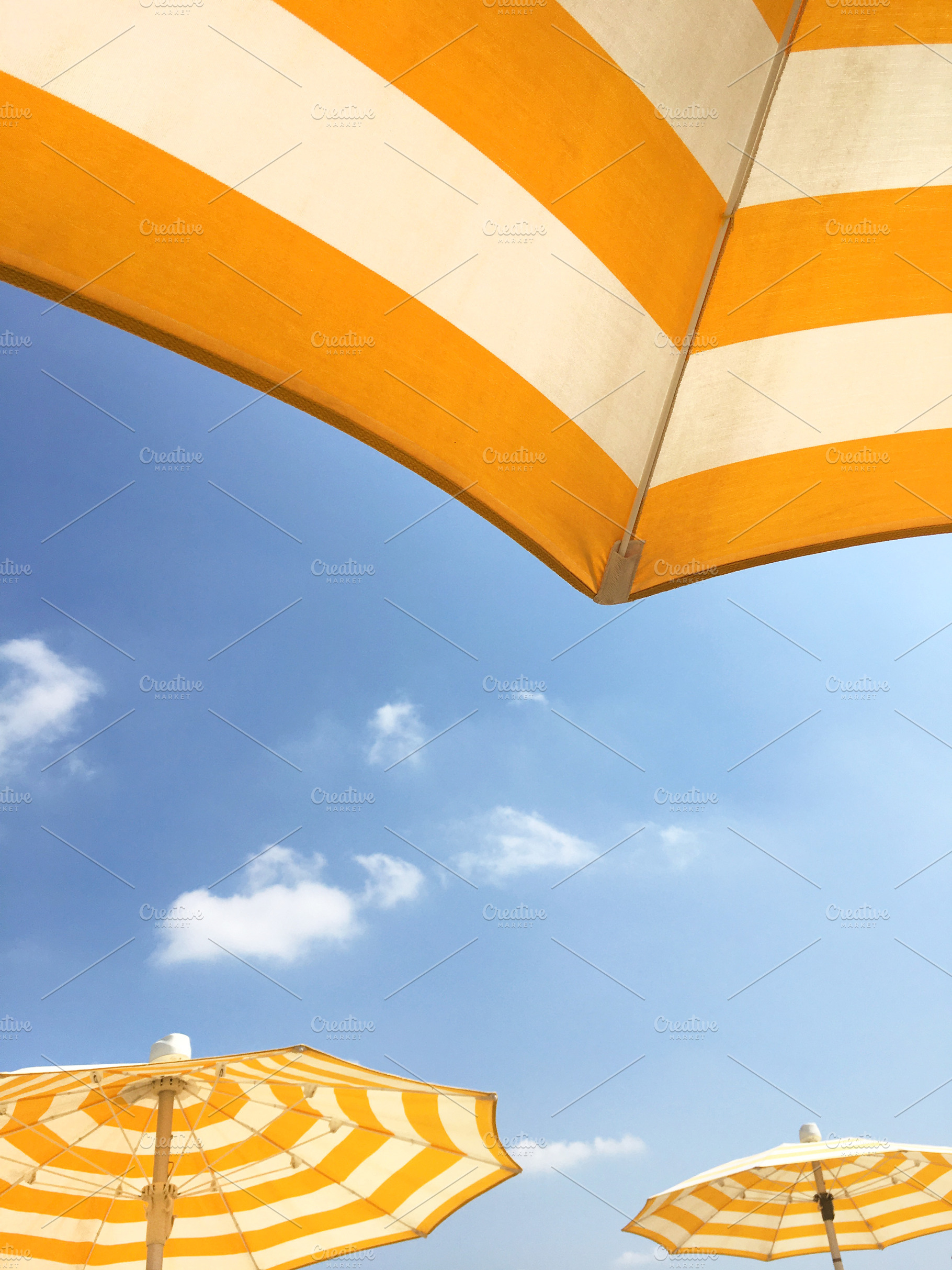 Yellow umbrellas on the beach, an Abstract Photo by KYNA STUDIO