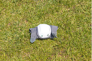 A gray elbow pad on the green grass, a Sports & Recreation Photo by Illustrations&photos