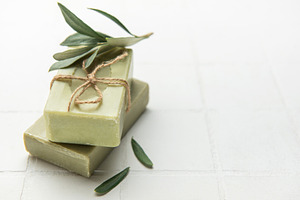 Natural olive soap bars decorated with olive tree branch on whit, a Beauty & Fashion Photo by Olena Rudo