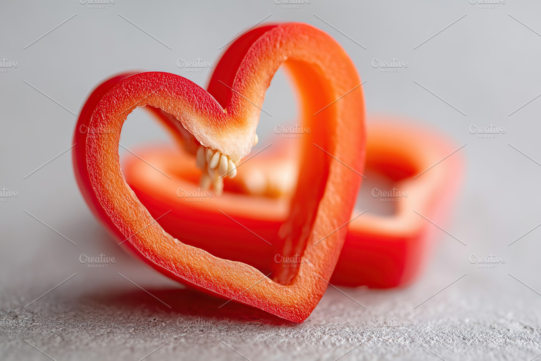 Heart-shaped slice of bell pepper displaying vibrant red color on a neutral bac, a Food & Drink Photo by AlyaAnd