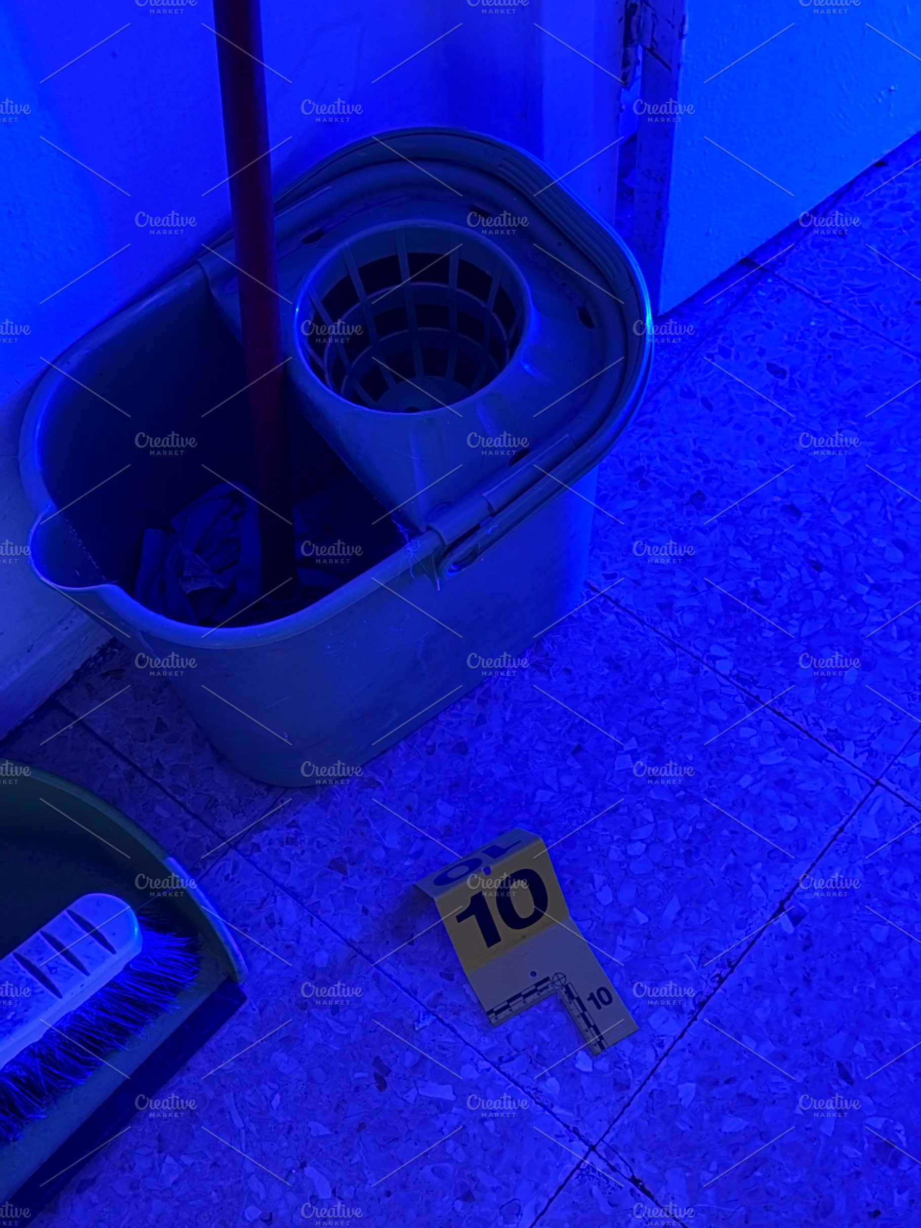 Crime scene evidence marker with mop bucket and blue light, an Industrial Photo by karrastock