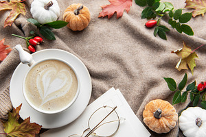 Autumn coziness with coffee, pumpkins, and fall leaves