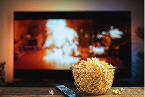 A glass bowl of popcorn and remote, a Technology Photo by Budarinphoto