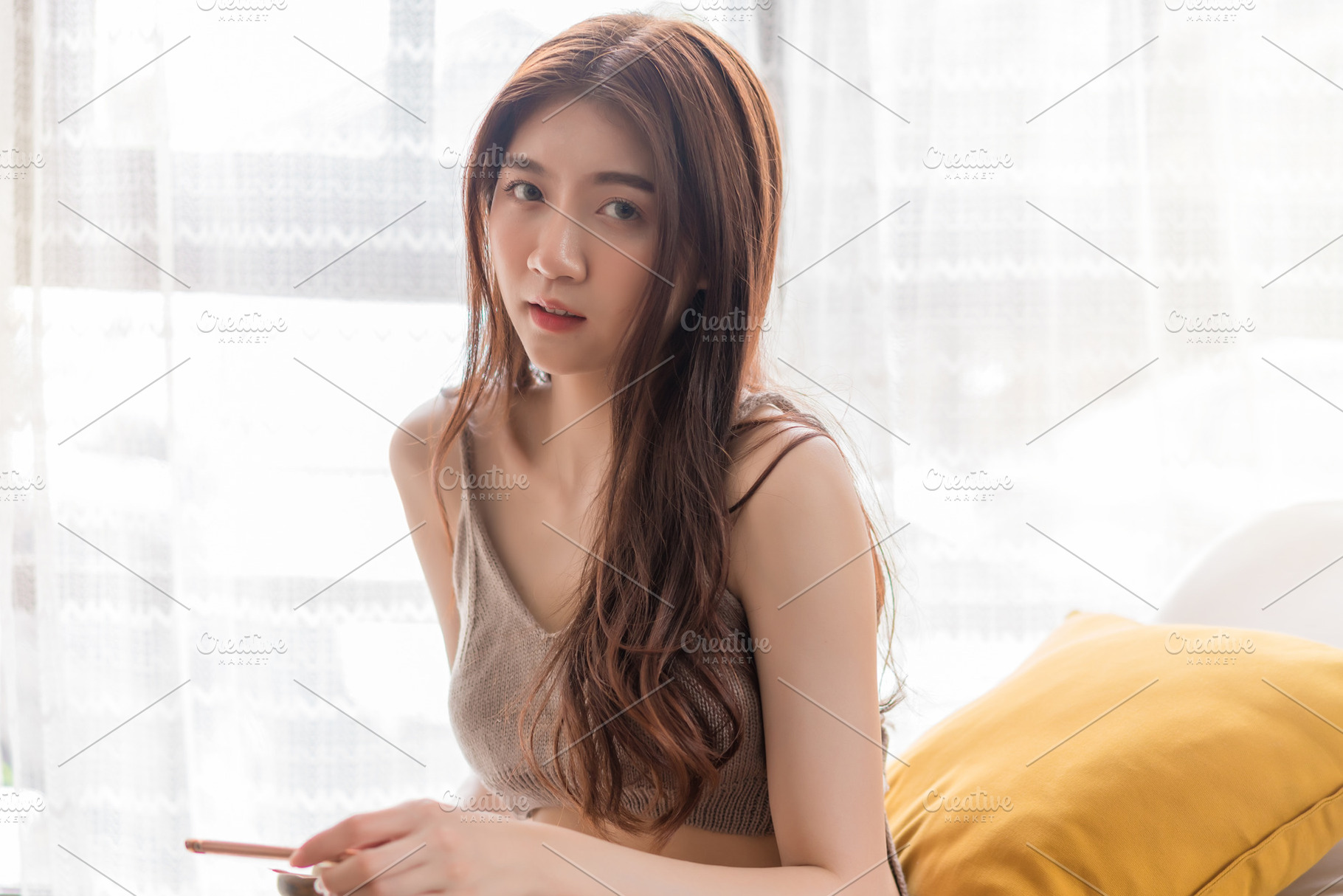 Asian woman relaxing sitting on sofa using smart phone at living, a Person Photo by Casanowe-studio