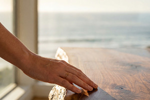 Woman's hand touching wood table, an Architecture Photo by Virgo Studio