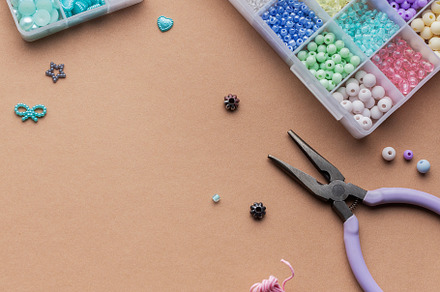 Crafting with colorful beads on a flat workspace with tools and, an Arts & Entertainment Photo by Olena Rudo